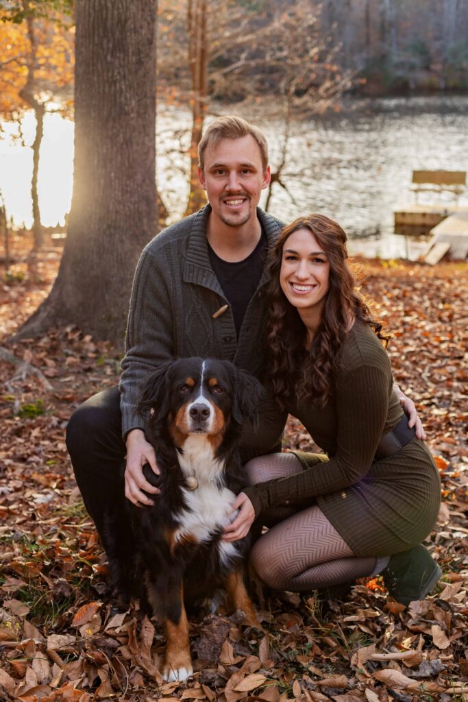 Couple and their Dog on a Private Property in Suffolk Virginia, at sunset in November with the golden hour light reflecting off the river behind them.