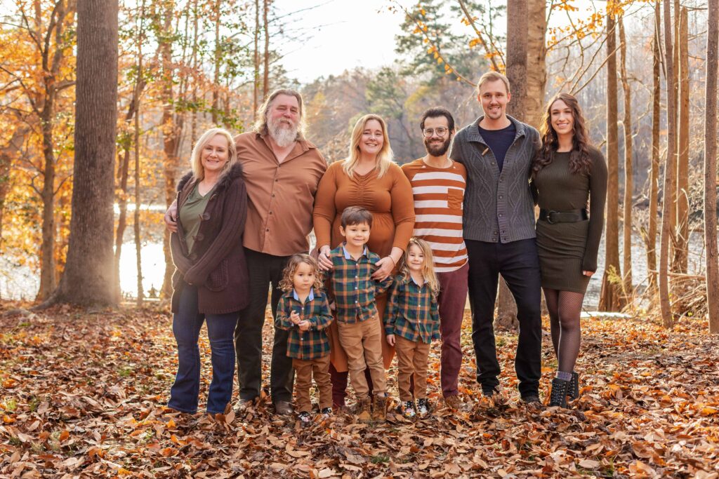 Multi-Generational Family with Grandparents, Siblings and young children, on a Private Property in Suffolk Virginia, at sunset in November with the golden hour light reflecting off the river behind them.